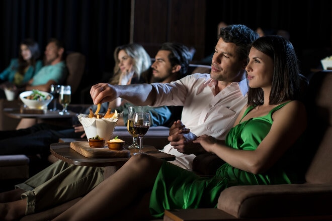 couple enjoying movie at cinema eating snacks