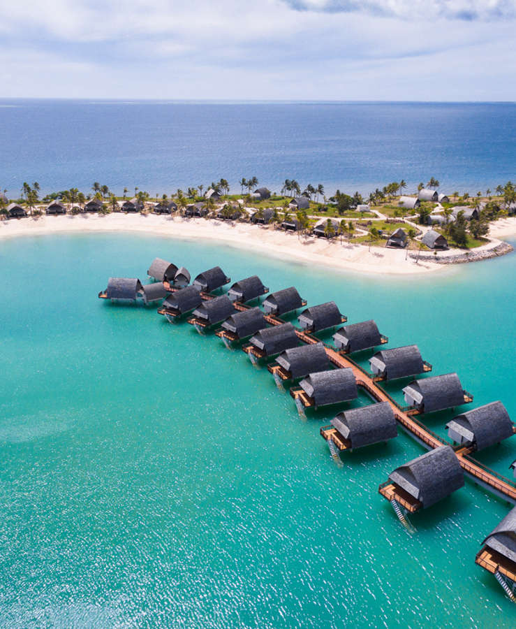 Aerial view of over-water bungalows and blue ocean