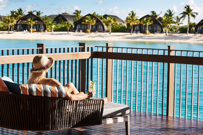 Woman looking at the ocean from her hotel room balcony