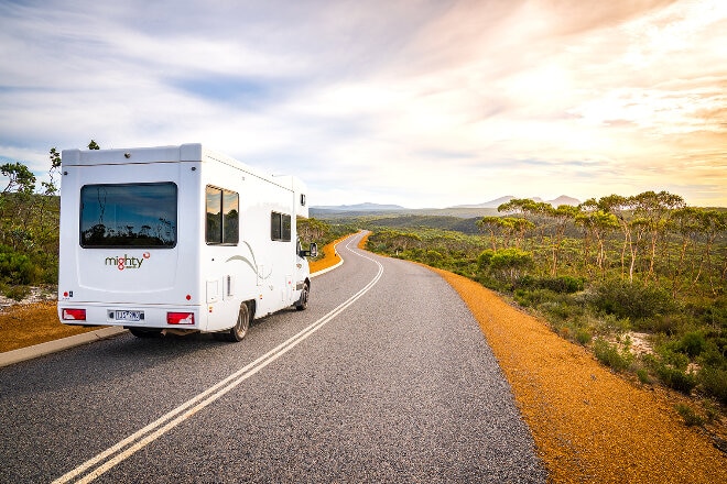 Mighty motorhome driving along the road through native bush