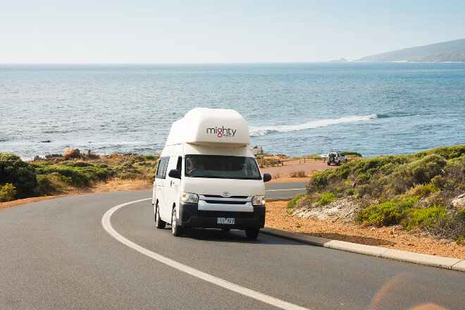 Mighty campervan driving along a coast road