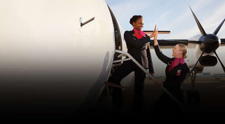 Qantaslink cabin crew high five while boarding a Q400 aircraft