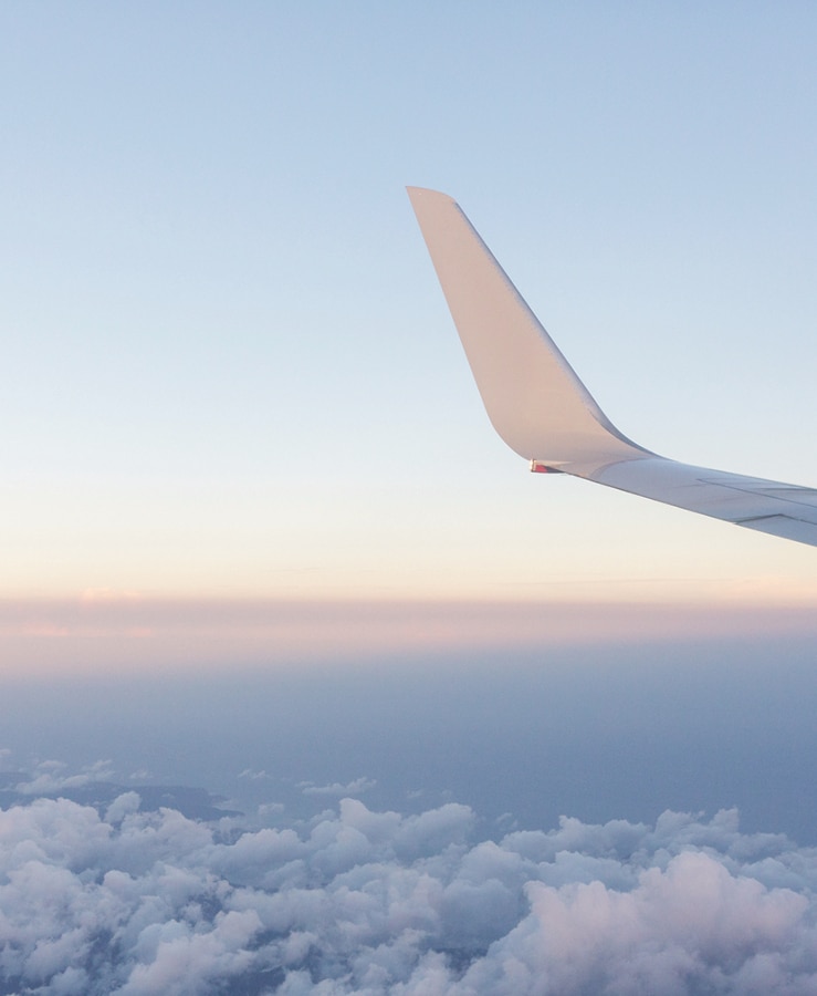 Aircraft wing inflight above the clouds