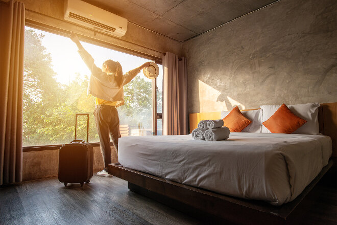 Woman at the window of an eco friendly hotel room