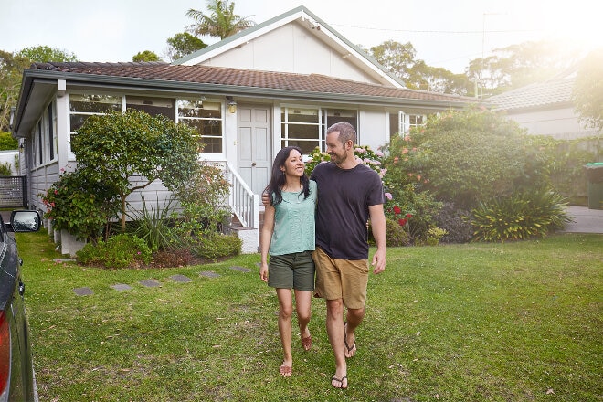 Man and woman standing in front of their home 