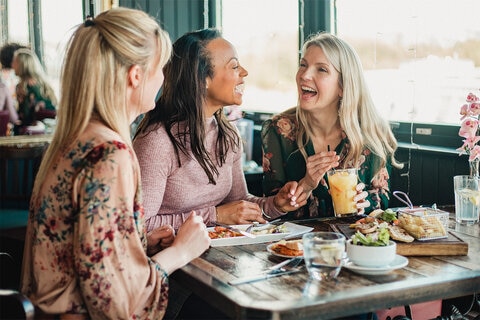 Three friends enjoying lunch at a cafe