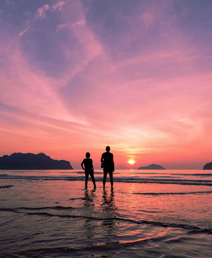 two people watching sunset at beach