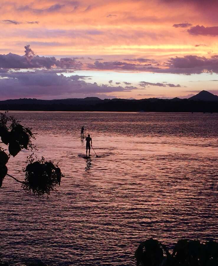 Paddleboarders on Sunshine Coast at sunset