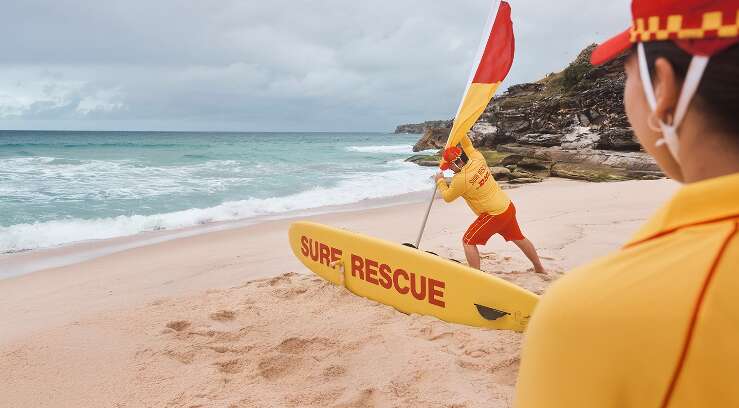 Surf Life Savers setting up flags on the beach