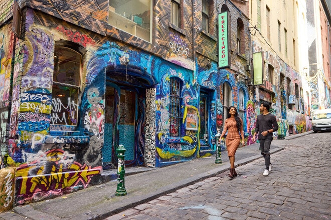 Couple walking through graffiti lanes in Melbourne