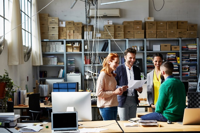 Group of four people in modern office space having a meeting