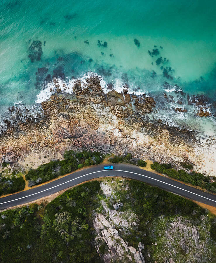 Aerial view of car driving along Point Picquet at Eagle Bay Beach, Dunsborough, Western Australia