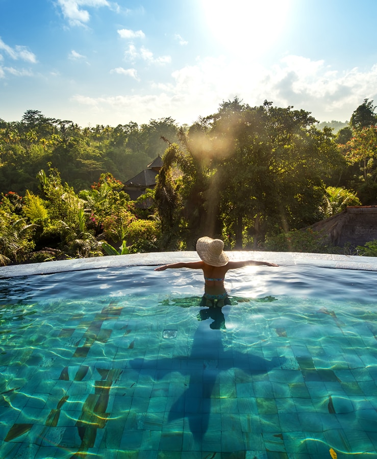 Guest looking out at native bushland from a hotel swimming pool