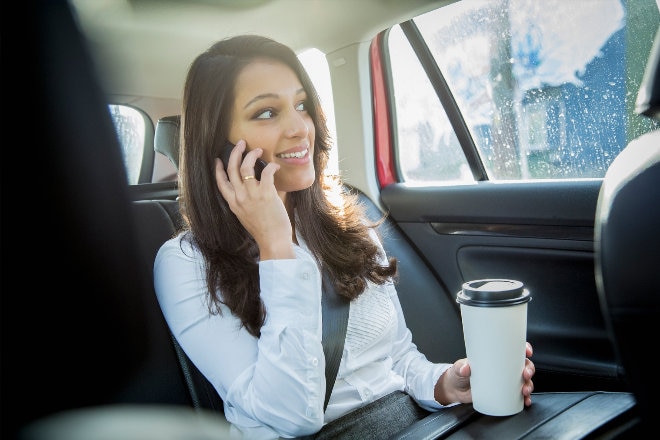 Female on the phone in back of car