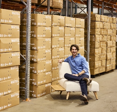 Ryan Lawson from Wattle Living sitting on the sustainably-made furniture product