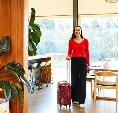 Lady walking luggage through lobby