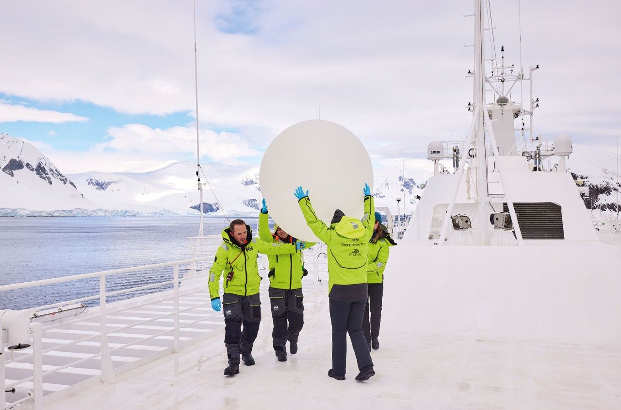 Crew prepare to launch a weather balloon from the Viking Polaris on a voyage in Antarctica