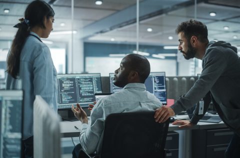 Workers gathered around a computer in the office