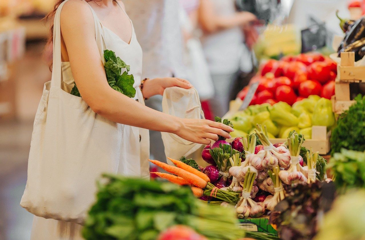 Woman choosing fresh fruit and vegetable produce at the supermarket