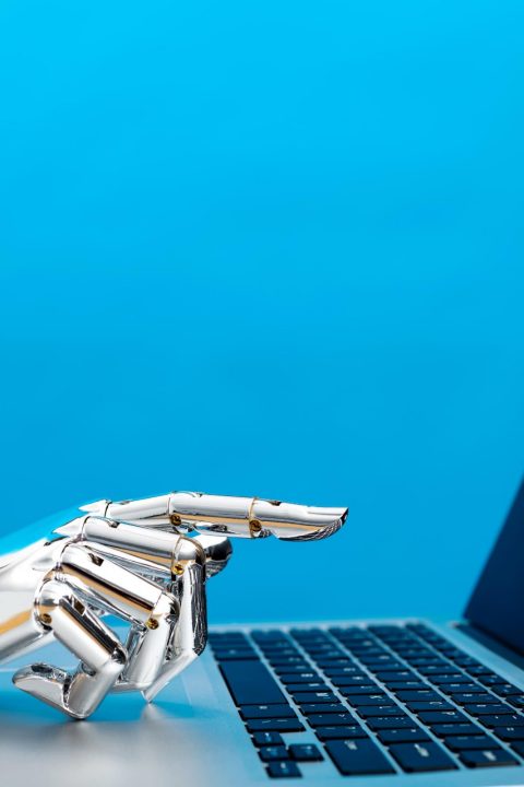 Robot hand pointing to laptop