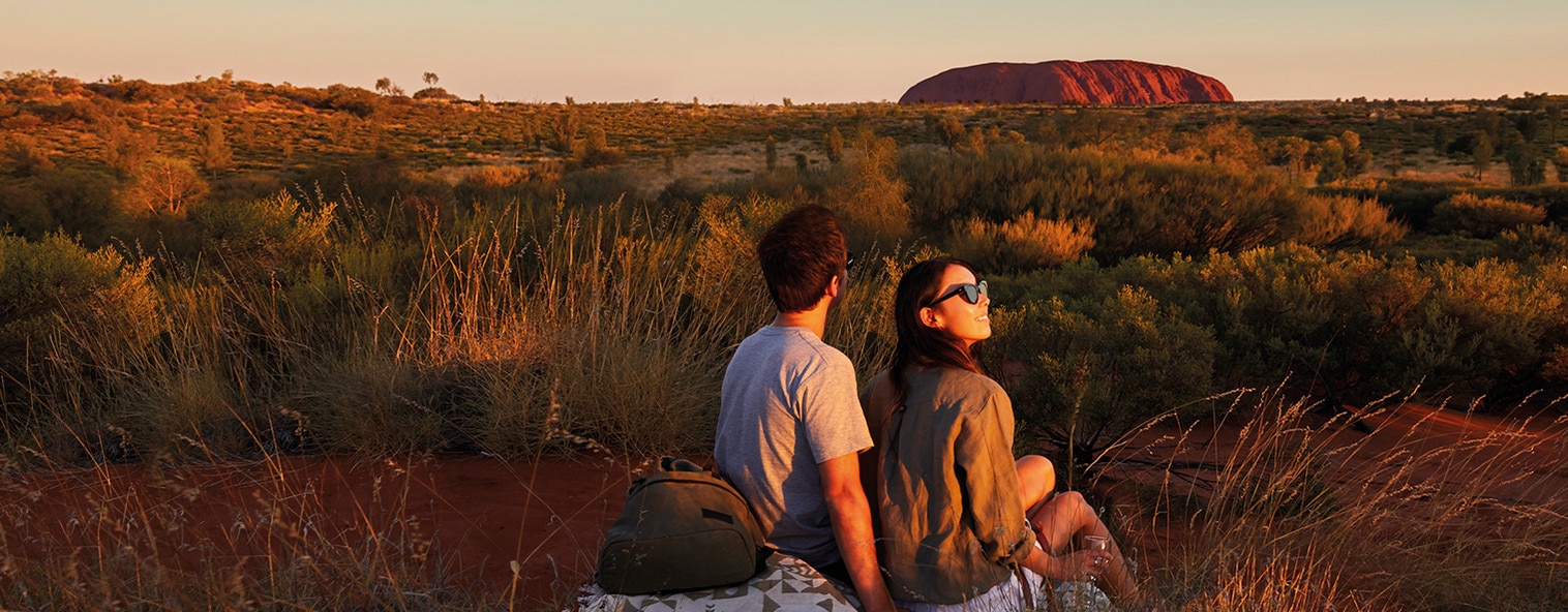 A couple sipping wine as they admire the beauty of The Olgas in Uluru