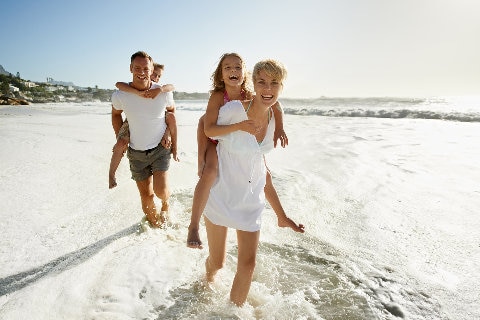 Family walking on white sand at beach