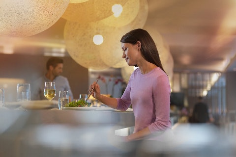 Woman enjoying a meal in the Qantas Club lounge