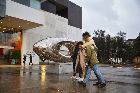 Friends arriving outside the Museum of Contemporary Art Australia in The Rocks, Sydney.